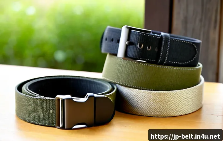 노스페이스 아웃도어 벨트와 콜롬비아 벨트 비교 - Photorealistic outdoor gear comparison on a clean light-wood table: two unbranded rugged fabric belt...